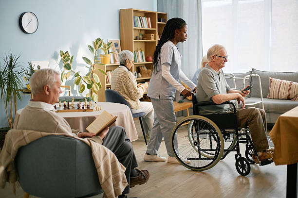istock Caring Nurse Assisting Elderly Man in Wheelchair 2216733900