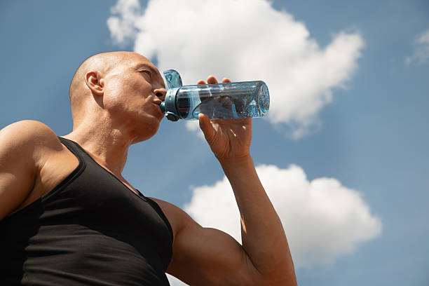 istock Athlete man drinking water on against sky. Outdoors. Water balance for for active workout. 2216734623