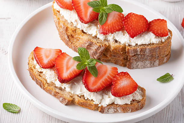 istock Freshly made strawberry toast with soft cheese on whole grain bread served on a white plate 2216735048