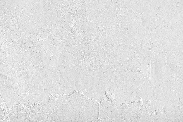 istock White concrete wall texture background. Uneven render stucco white painted concrete wall texture background. 2216738538