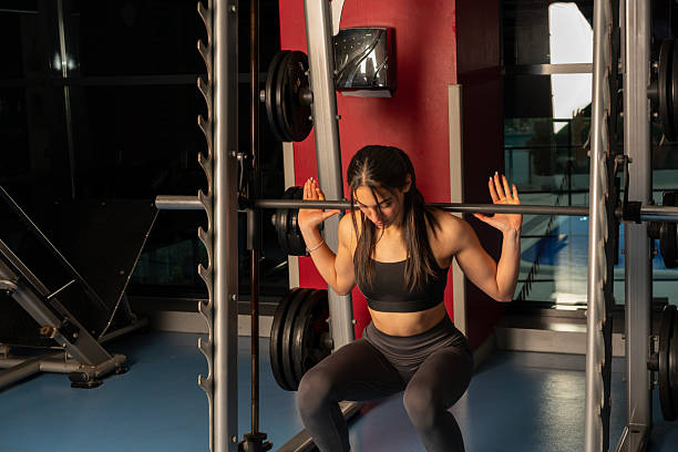 istock Athletic young woman doing some weightlifting exercises, barbell Squat 2216739343