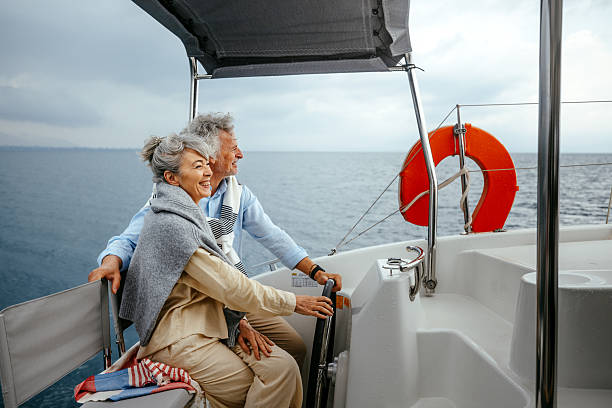 Senior couple casually sailing a catamaran together