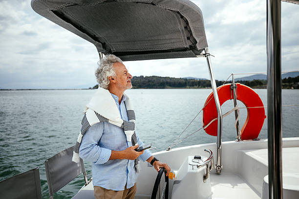 istock Casually clothed senior man driving a catamaran 2216739636