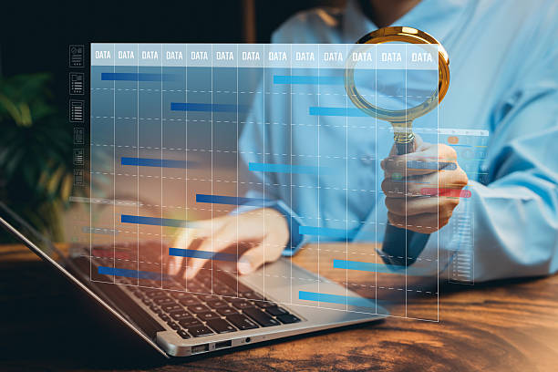 istock Business Analyst Examining Data Trends on Laptop with Magnifying Glass in Office Environment, Business concept 2216740985