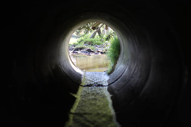 istock View through a round concrete tunnel carrying a stream beneath a road 2216742880