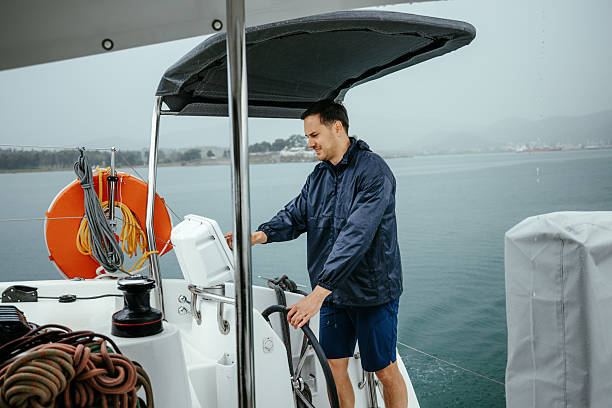 Young skipper riding catamaran on rainy day