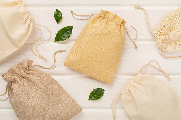 istock Small eco sacks on wooden background, top view 2216756255
