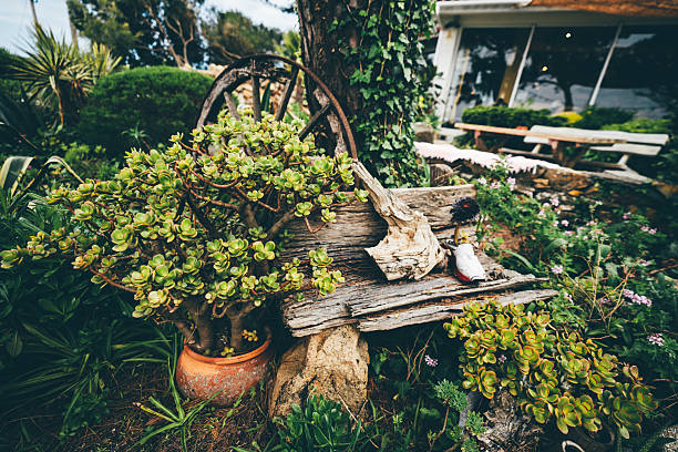 Nostalgic garden design with flowers, old chair and stone figures.