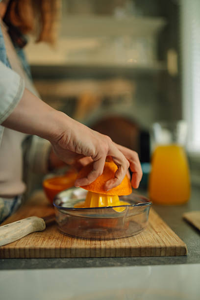 istock Woman squeezing fresh orange juice in the kitchen 2216760787