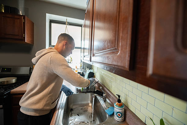 istock Hispanic Man Washing Dishes at Home with Rubber Gloves 2216765805
