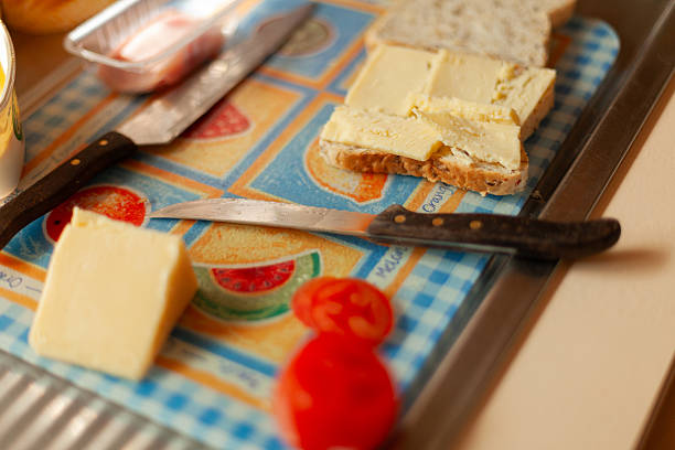 View of preparations to make a sandwich of sliced bread, cheese and tomato on a kitchen bench