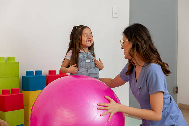 istock Pediatrician playing with young patient using an exercise ball in her office 2216773551