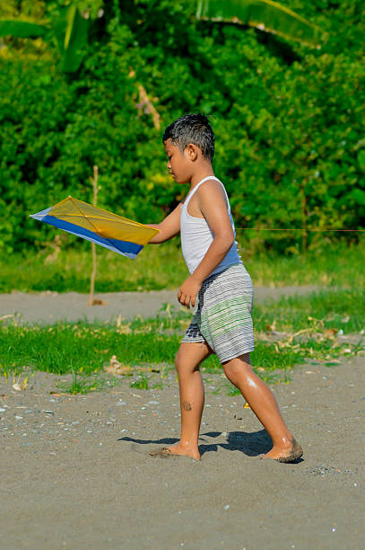 The young boy walks confidently with the kite in hand, ready for another round of fun.