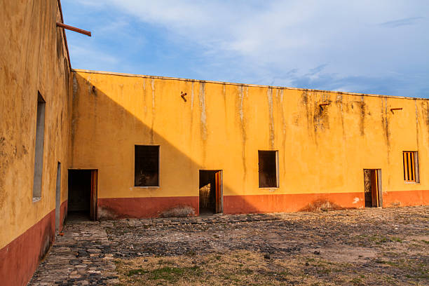 The Isla del Presidio fortress (Mezcala Island) is located in the middle of Lake Chapala, opposite the town of Mezcala de la Asunción (Jalisco) and on the border with Michoacán. This small island (approximately 20–25 ha) offers a freshwater lake environment and varied vegetation (rubber trees, plum trees). The military building, erected by insurgents during the War of Independence, has high stone walls, an access drawbridge, and a double-sloped perimeter moat. Its layout consists of four bays around a cobbled courtyard with 28 cubicles (cells) and features two circular watchtowers (one known as San Juan Bautista). This fortification is the most important vestige of insurgent resistance in Jalisco; its walls, moat, and towers withstood royalist attacks, and it is also \
