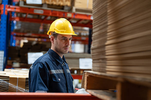 istock Man warehouse worker wearing uniform and helmet safety standing with clipboard for checking stock products on shelves in warehouse 2216783030