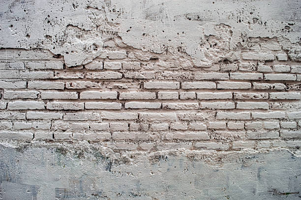 istock A heavily textured white brick wall with peeling paint and crumbling plaster, offering a versatile aged background. Ideal for grunge, vintage, and industrial design projects 2216783401