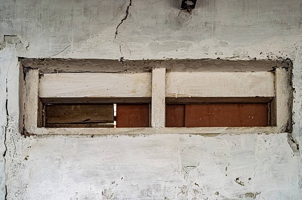 interplay of resilience and decay, showcasing concrete patches on a crack in a brick wall symbolizing attempts to mend the passage of time and structural wear