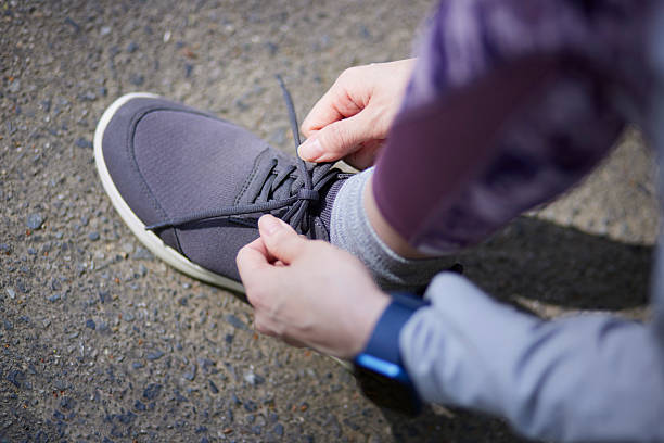 istock Woman's hands tying shoelaces for running shoes 2216786871