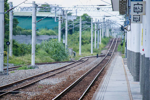 istock Taiwan May 21, 2024: A railway track curving into the distance beside a station platform, surrounded by greenery and power poles Fuli Station and Train in Taiwan 2216792242