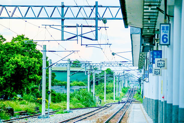 istock Taiwan May 21, 2024: A railway track curving into the distance beside a station platform, surrounded by greenery and power poles Fuli Station and Train in Taiwan 2216792244