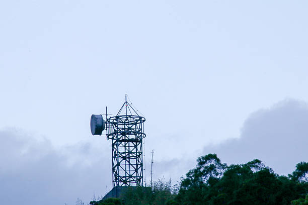 A communication antenna tower standing on a hillside with cloudy blue sky in the background Fuli Station and Train in Taiwan