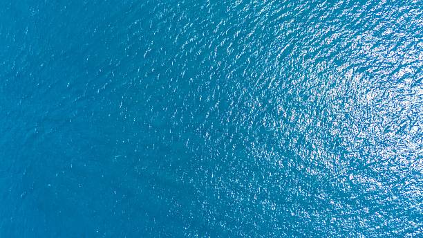 istock Aerial view of ocean surface with sunlight reflections. 2216793543