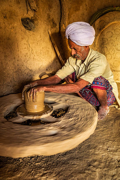 Indian potter working in his workshop, desert village in Rajasthan, India