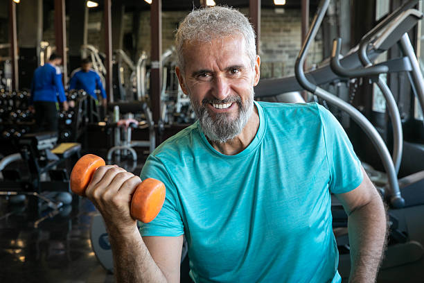 istock Senior Man Having Strength Exercise in Gym with Weights 2216796758