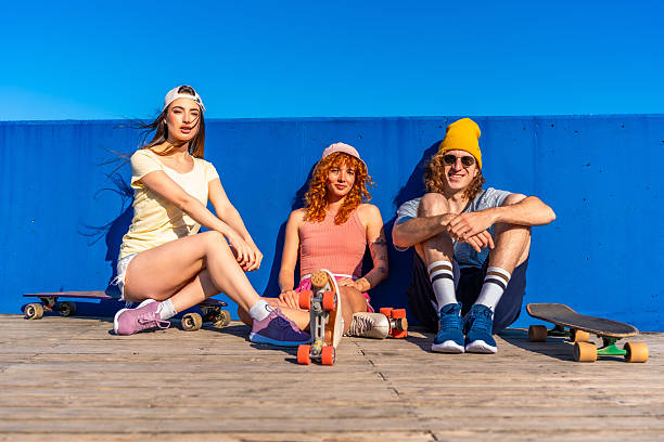 istock Young people posing with skateboards and roller skates by blue wall 2216797502