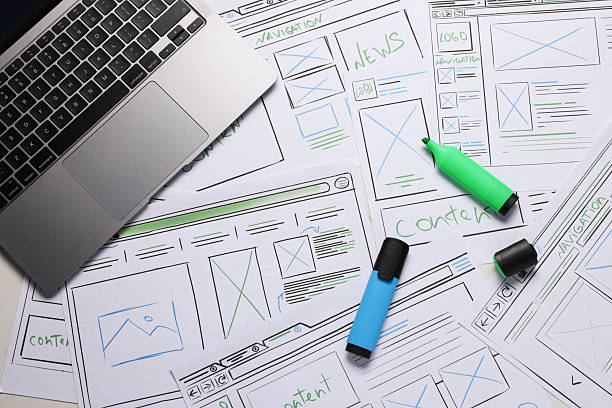 istock Developing UI design. Sketches of website wireframes, laptop and felt pens on table, top view 2216798219