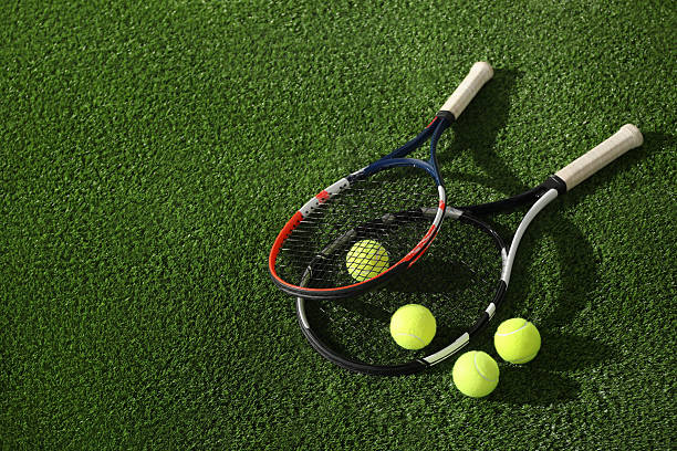 istock Tennis rackets and balls on green artificial grass, flat lay. Space for text 2216799143