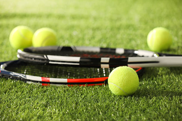 istock Tennis rackets and balls on green artificial grass, closeup 2216799152