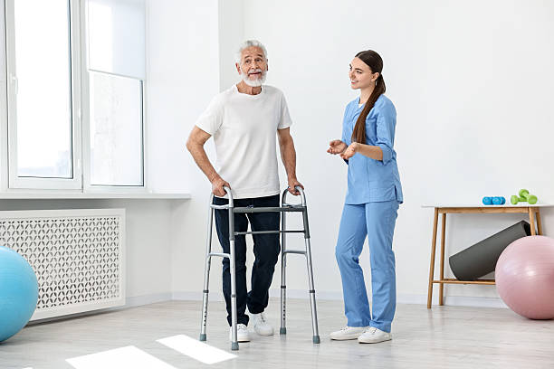 istock Nurse talking to senior man with walking frame in clinic 2216799271