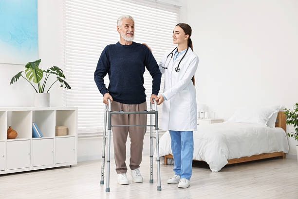 istock Doctor helping senior man with walking frame in clinic 2216799291