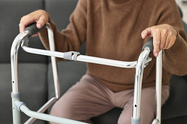istock Senior man with walking frame on sofa at home, closeup 2216799329