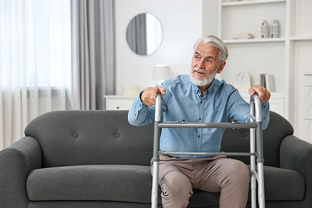 istock Senior man with walking frame on sofa at home 2216799384