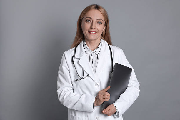istock Doctor with stethoscope and laptop on gray background 2216799850