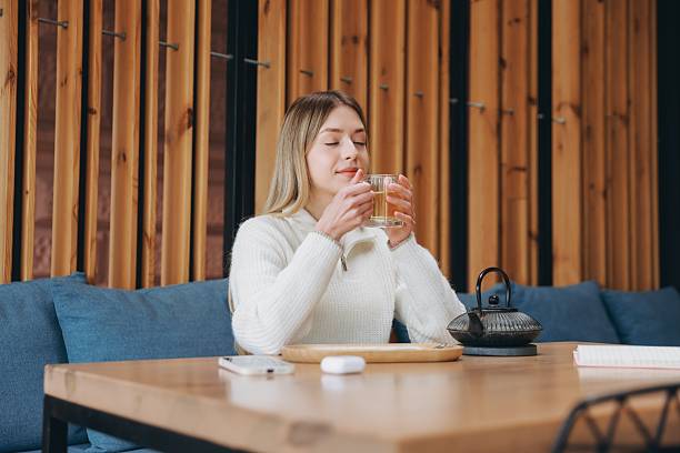 istock Young Woman Enjoying Tea in Modern Cafe 2216800168