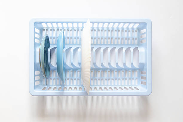 Plates in a blue plastic dish drainer in the kitchen, top view, cleanliness and home concept, clean dishes