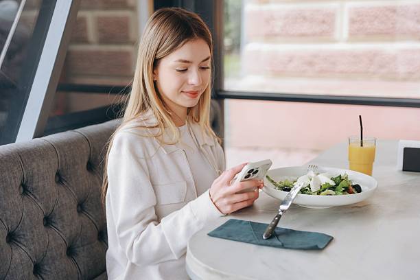 istock Businesswoman using smartphone while having lunch break in restaurant 2216801435