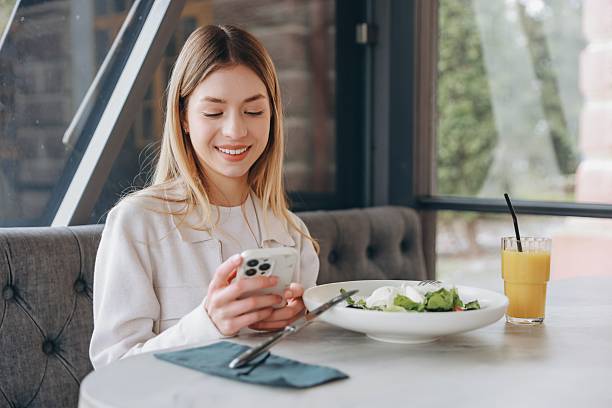 istock Businesswoman using smartphone while having lunch break in restaurant 2216801451