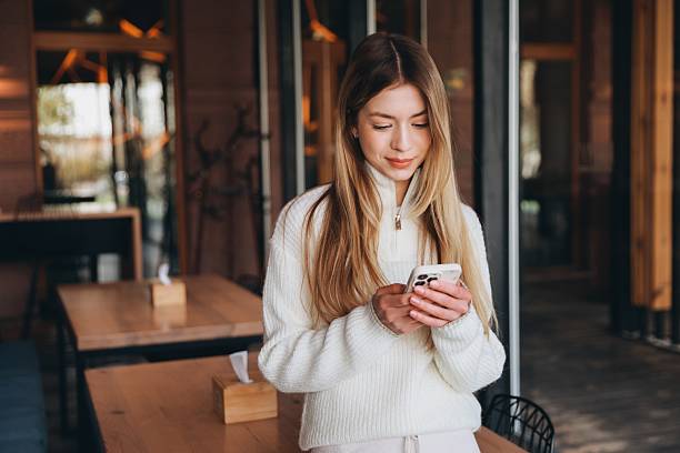 istock Young woman using smartphone in a cafe 2216801547