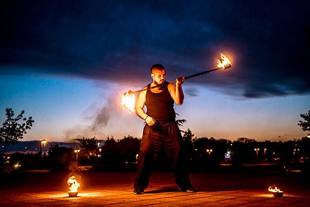 istock Fire performer displaying skill with flaming staff 2216802515