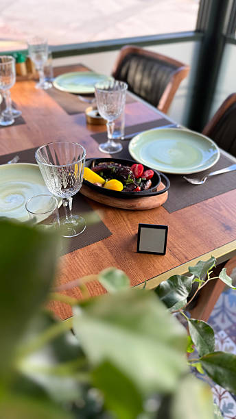 Colorful place setting indoors in restoran on table crockery and cutlery. Octopus and seafood stew.