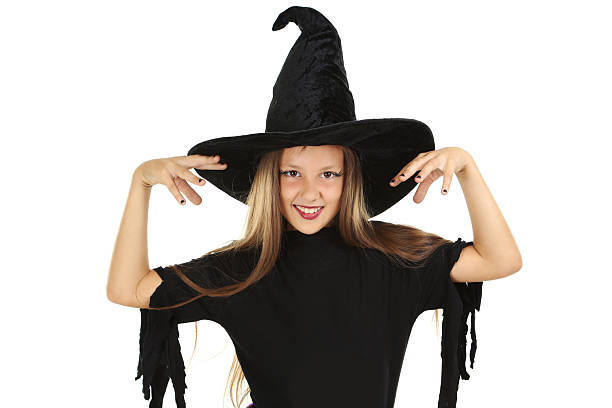Little girl with witches hat hiding in the woods. Note for inspection; hat is not branded by any company, random hat.
