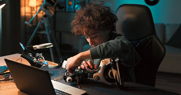 istock A smiling boy prepares a robot for a school competition. The talented student twists screws and proudly assembles the entire toy from scratch with great focus and joy. 2216804133