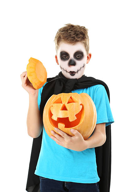 istock Little boy in halloween costume with pumpkin on white background 2216804340