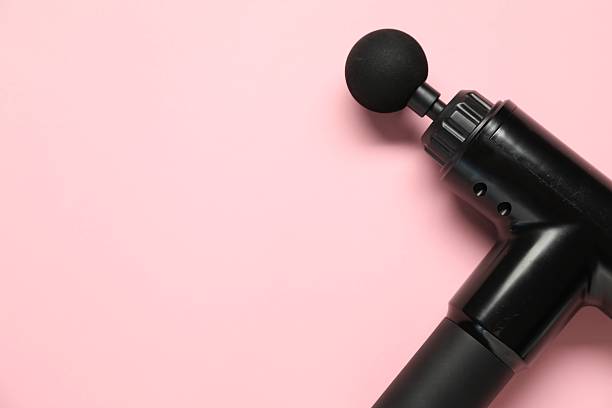 istock One black percussive massager on pink background, above view. Space for text 2216804494