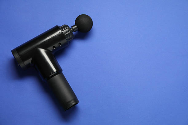 istock One black percussive massager on blue background, above view. Space for text 2216804540