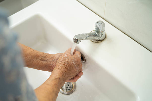 istock Asian elderly woman washing hands in bathroom. 2216806508